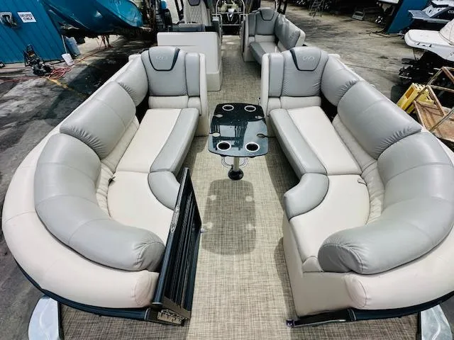 Slide: The Image of 2019 Harris 270 Grand Mariner pontoon boat interior with plush seating and central table. - 17