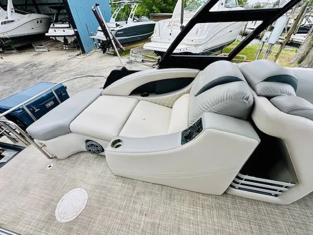 Slide: The Image of 2019 Harris 270 Grand Mariner boat with luxurious seating and sleek design in a marina setting. - 6
