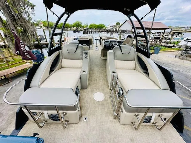 Slide: The Image of 2019 Harris 270 Grand Mariner pontoon boat with luxurious seating and modern design at a marina. - 9