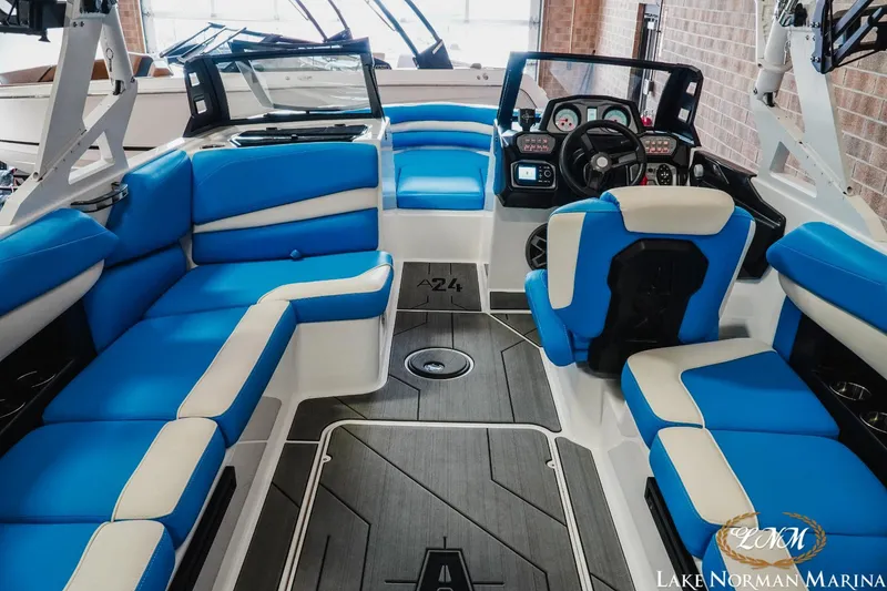 Slide: The Image of 2019 Axis A24 boat interior with blue and white seating, modern dashboard, and spacious layout. - 10