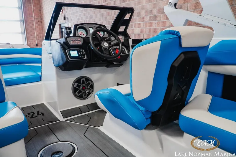Slide: The Image of 2019 Axis A24 boat interior with blue and white seating, modern dashboard, and steering wheel. - 13