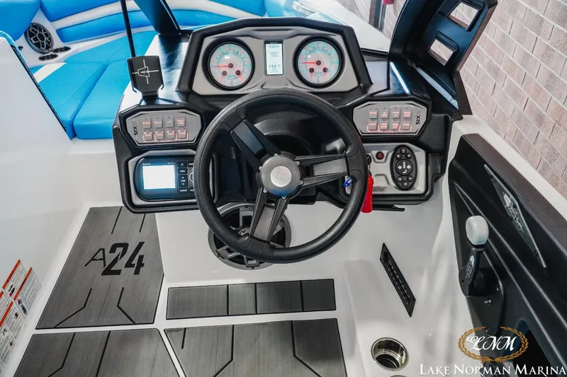 Slide: The Image of 2019 Axis A24 boat dashboard with steering wheel, gauges, and control panels. - 14