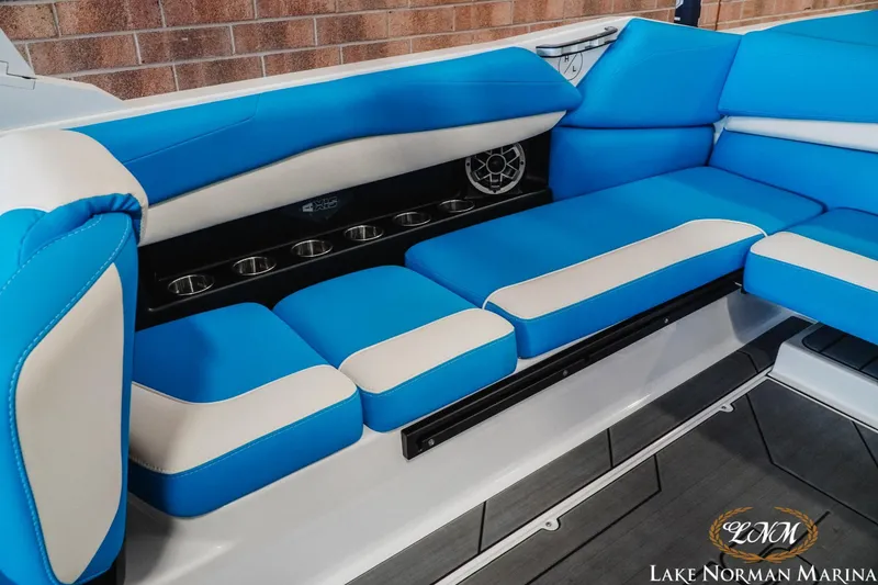 Slide: The Image of 2019 Axis A24 boat interior with blue and white seating, cup holders, and speaker. - 20