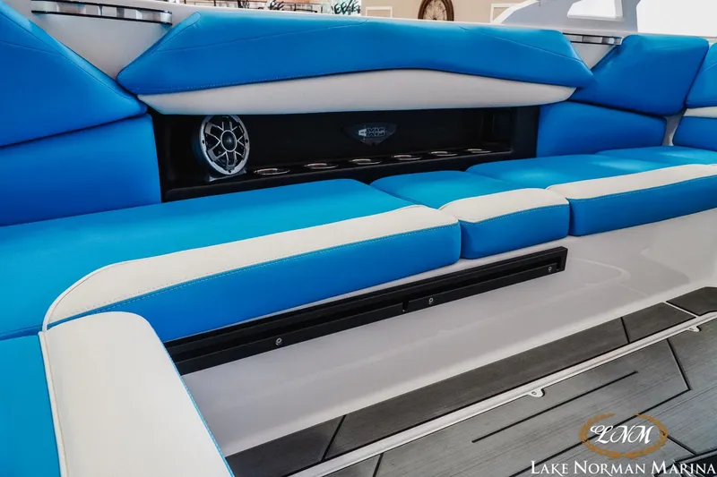 Slide: The Image of 2019 Axis A24 boat interior with blue and white seating, speaker, and cup holders. - 21