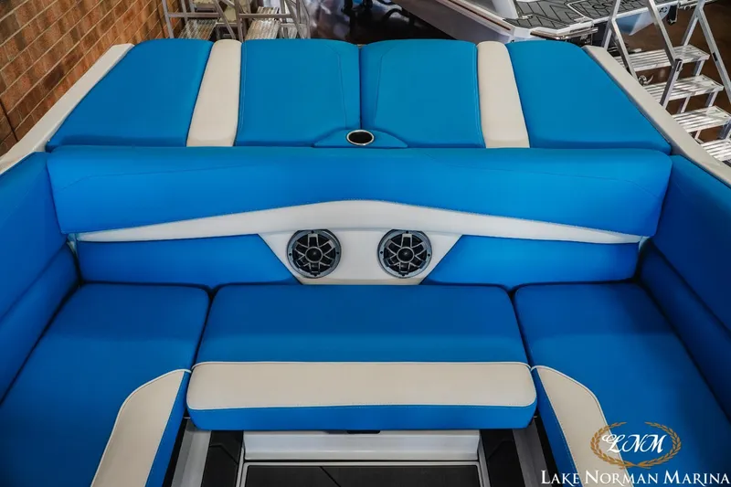 Slide: The Image of 2019 Axis A24 boat interior with blue and white seating, featuring built-in speakers. - 22