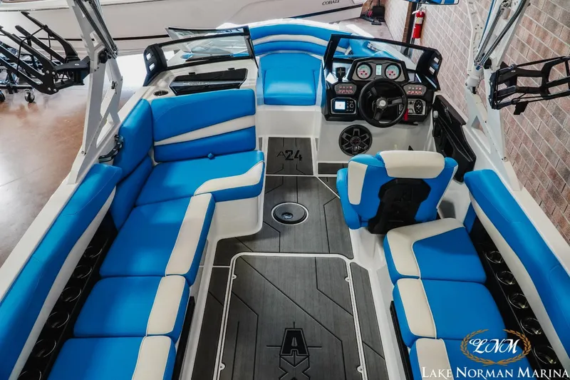 Slide: The Image of 2019 Axis A24 boat interior with blue and white seating, modern dashboard, and spacious layout. - 9