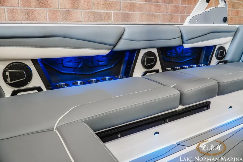 Slide: The Image of 2024 Axis A245 boat interior with gray seating, blue LED lighting, and cup holders. - 17