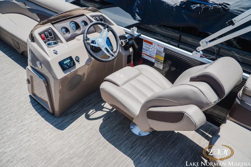 Slide: The Image of 2024 Bennington 20SSR boat helm with steering wheel and comfortable captain's chair at Lake Norman Marina. - 10