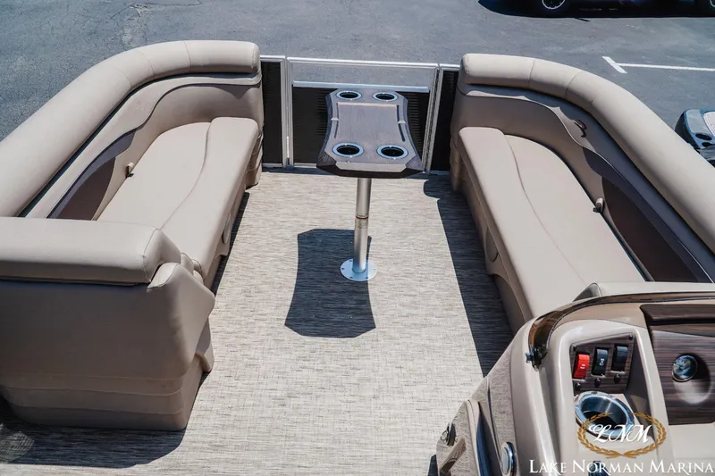 Slide: The Image of 2024 Bennington 20SSR pontoon boat interior with beige seating and table. - 6