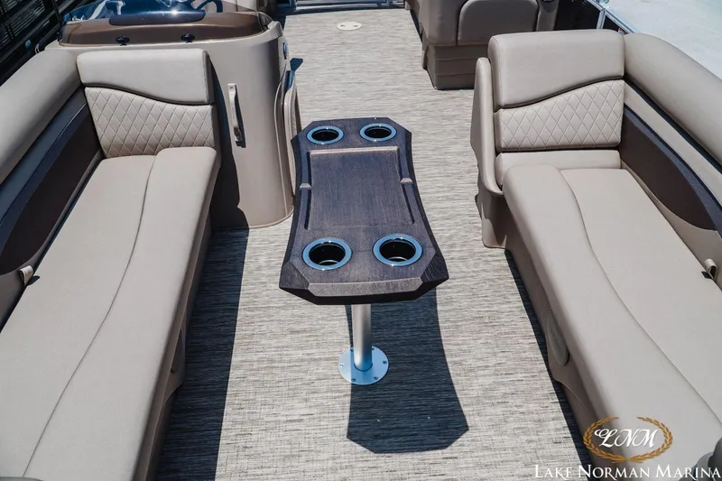 Slide: The Image of 2024 Bennington 20SSR pontoon boat interior with beige seating and central table. - 8