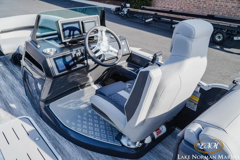Slide: The Image of 2025 Bennington 22MFB boat interior with modern dashboard and steering wheel at Lake Norman Marina. - 11