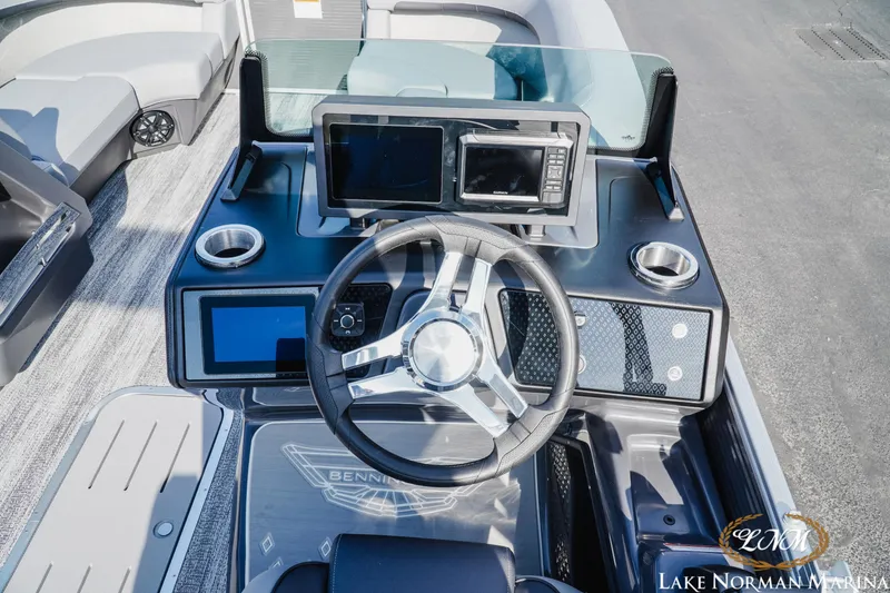 Slide: The Image of 2025 Bennington 22MFB boat dashboard with steering wheel and digital displays. - 12
