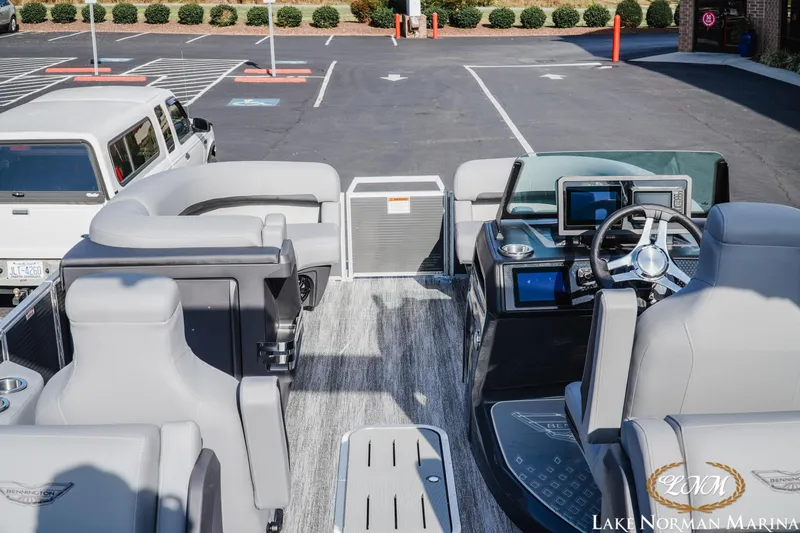 Slide: The Image of 2025 Bennington 22MFB boat interior with modern helm, parked in a marina lot. - 8