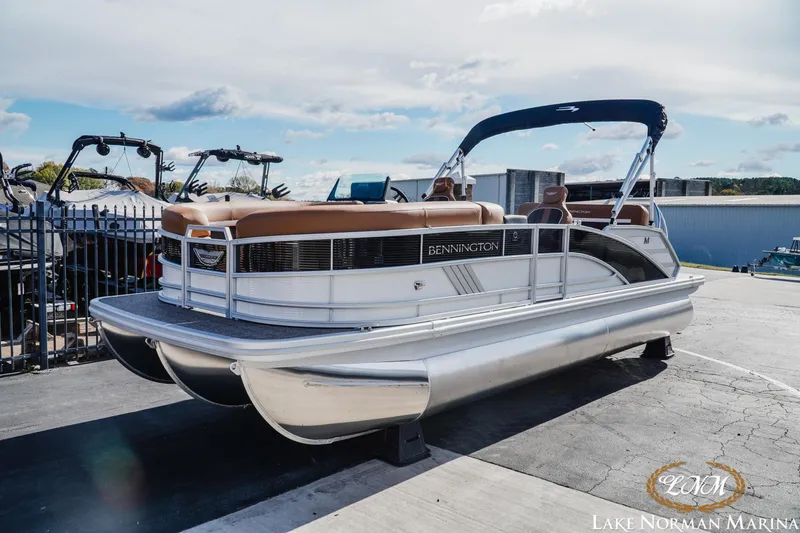 Slide: The Image of 2025 Bennington 22MSB pontoon boat at Lake Norman Marina, featuring sleek design and comfortable seating. - 2