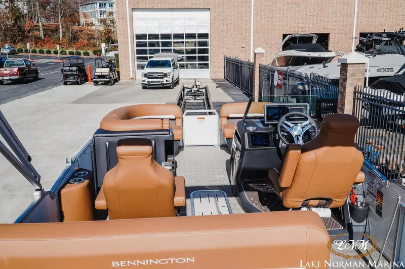 Slide: The Image of 2025 Bennington 22MSB pontoon boat interior at Lake Norman Marina, featuring tan seating and modern controls. - 5