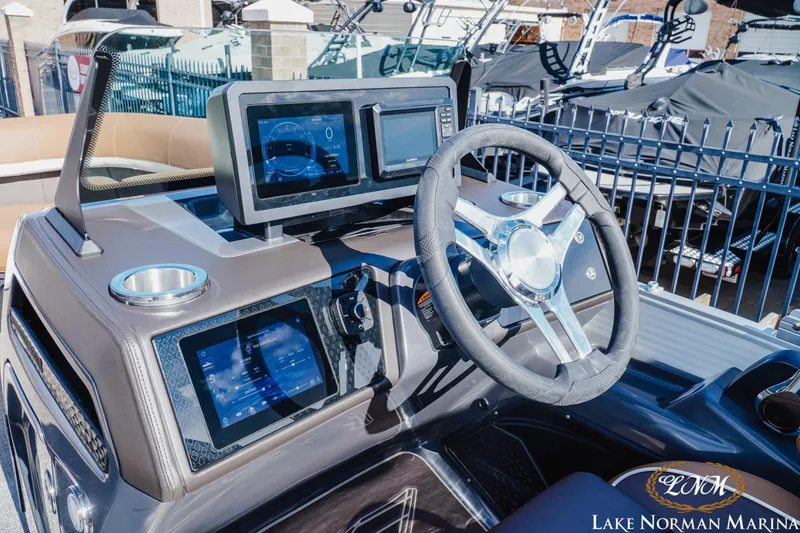 Slide: The Image of 2025 Bennington 22MSB boat dashboard with modern steering wheel and digital displays at Lake Norman Marina. - 7