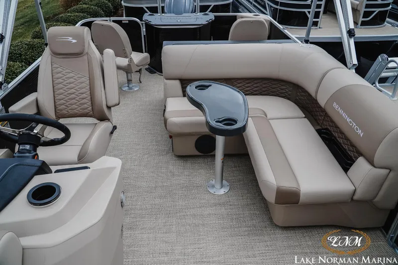 Slide: The Image of 2024 Bennington 22ss-sps pontoon boat interior with beige seating and table. - 14