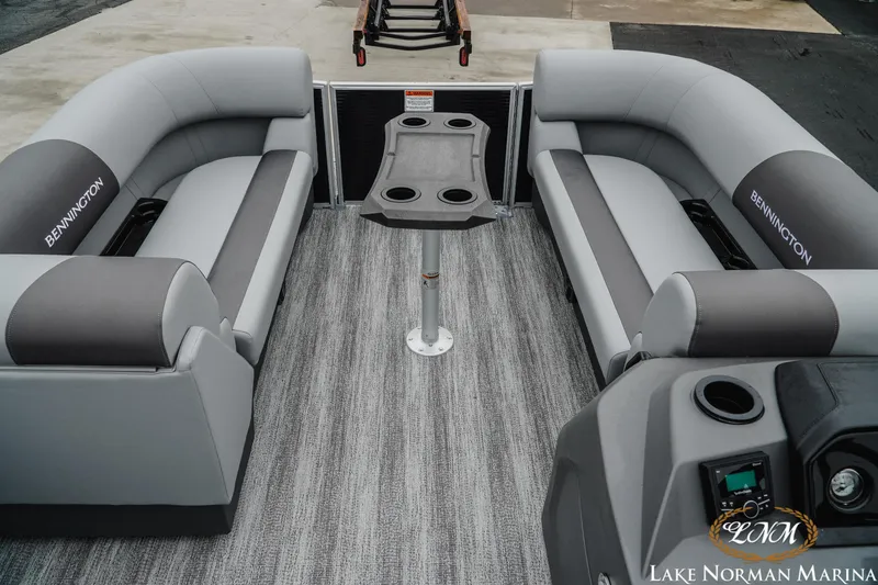 Slide: The Image of 2025 Bennington 22SSR pontoon boat interior with gray seating and central table. - 11