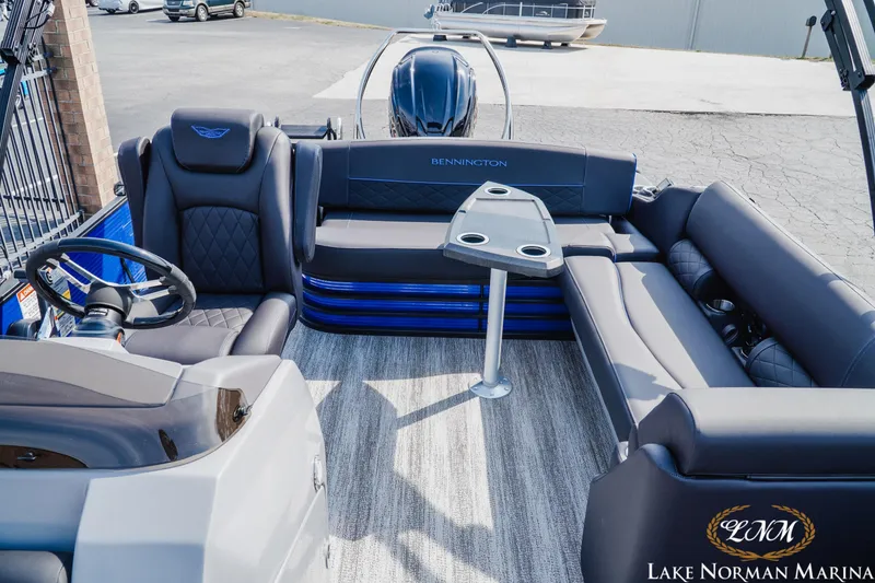 Slide: The Image of 2025 Bennington 23LSB pontoon boat interior with plush seating and steering console. - 14