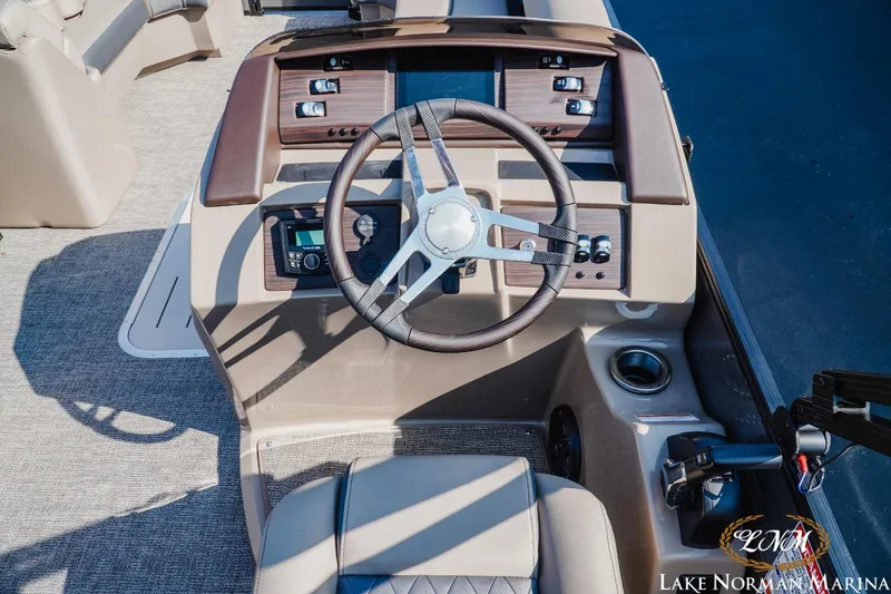 Slide: The Image of 2025 Bennington 23LSB boat dashboard with steering wheel and controls at Lake Norman Marina. - 10