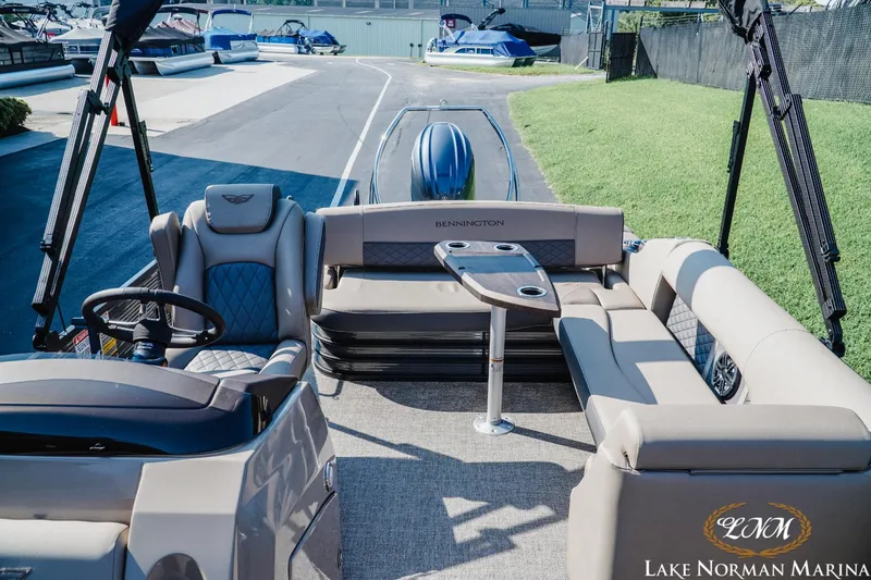 Slide: The Image of 2025 Bennington 23LSB pontoon boat interior with seating and steering wheel at Lake Norman Marina. - 14