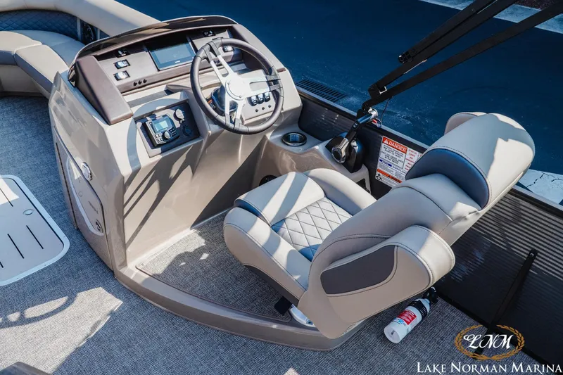 Slide: The Image of 2025 Bennington 23LSB boat interior with steering console and captain's chair at Lake Norman Marina. - 9