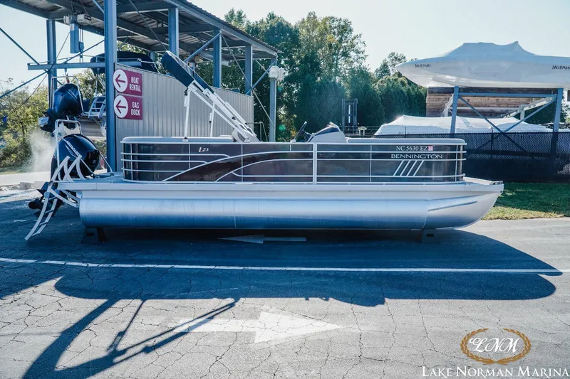 Slide: The Image of 2023 Bennington 23LSR pontoon boat at Lake Norman Marina, parked near gas dock. - 1