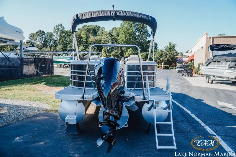 Slide: The Image of 2023 Bennington 23LSR pontoon boat at Lake Norman Marina, featuring a powerful outboard motor. - 5
