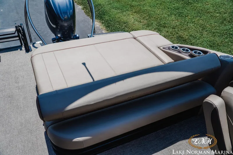 Slide: The Image of 2024 Bennington 23LXSSB boat interior with beige seating and cup holders at Lake Norman Marina. - 15