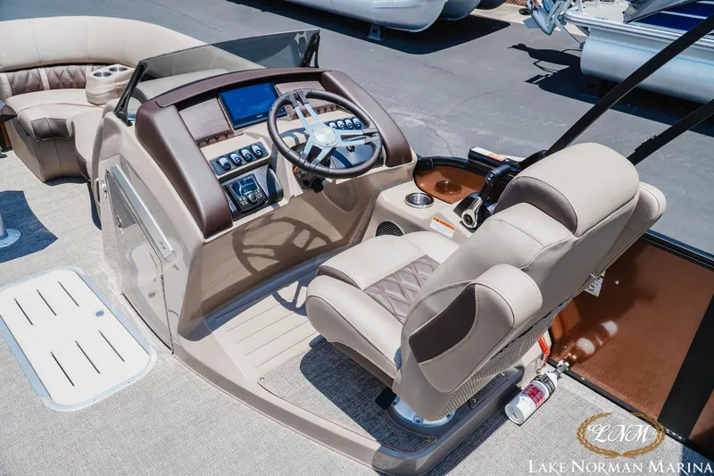 Slide: The Image of 2024 Bennington 23LXSSB boat interior with helm, steering wheel, and seating at Lake Norman Marina. - 8