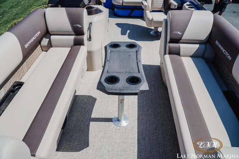 Slide: The Image of 2025 Bennington 23ssb pontoon boat interior with seating and table at Lake Norman Marina. - 12