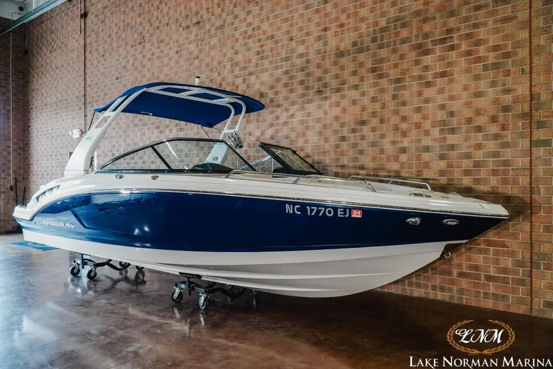 Slide: The Image of 2018 Chaparral 227 SSX boat with blue hull, displayed indoors at Lake Norman Marina. - 2