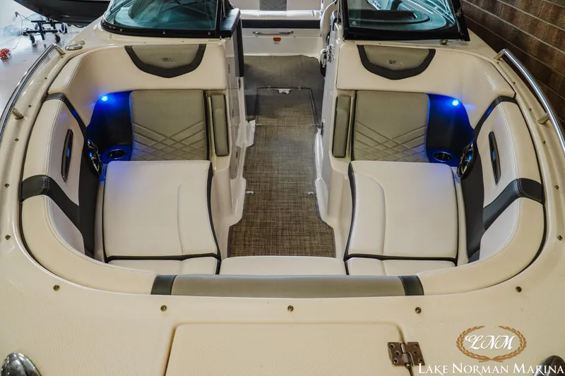 Slide: The Image of 2018 Chaparral 267 SSX boat interior with white seating and blue LED lights. - 6