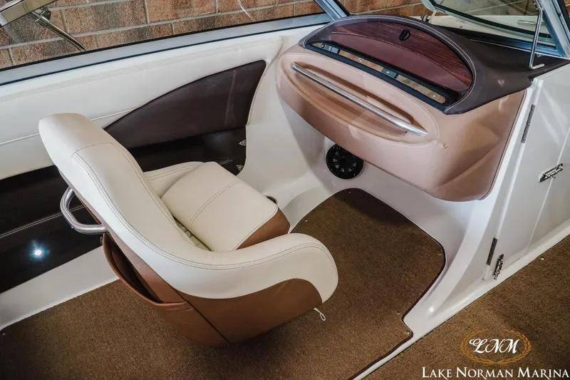 Slide: The Image of 2015 Cobalt 210 boat interior with beige and brown seating, dashboard, and carpet. - 11