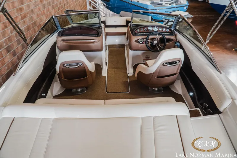 Slide: The Image of Interior of a 2015 Cobalt 210 boat at Lake Norman Marina, featuring brown and white seating. - 7