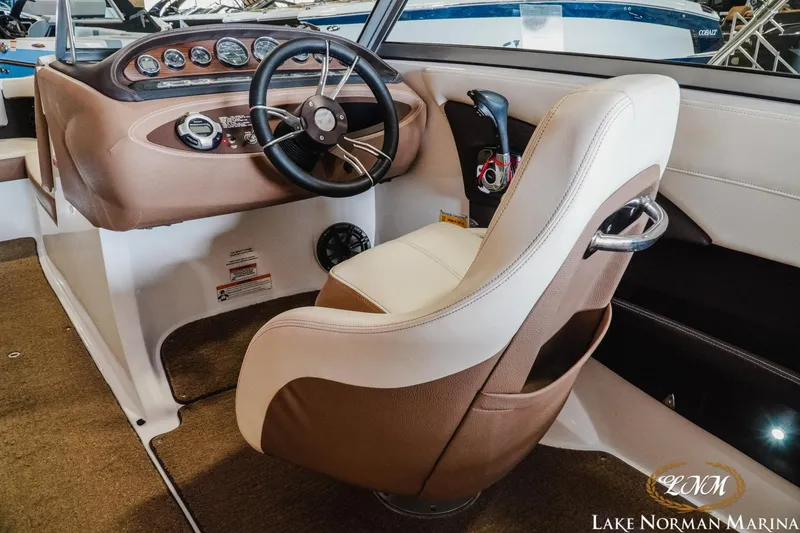 Slide: The Image of Interior of a 2015 Cobalt 210 boat with steering wheel and dashboard controls. - 9