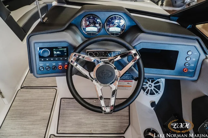 Slide: The Image of 2024 Cobalt CS22 boat dashboard with steering wheel and control panel at Lake Norman Marina. - 11