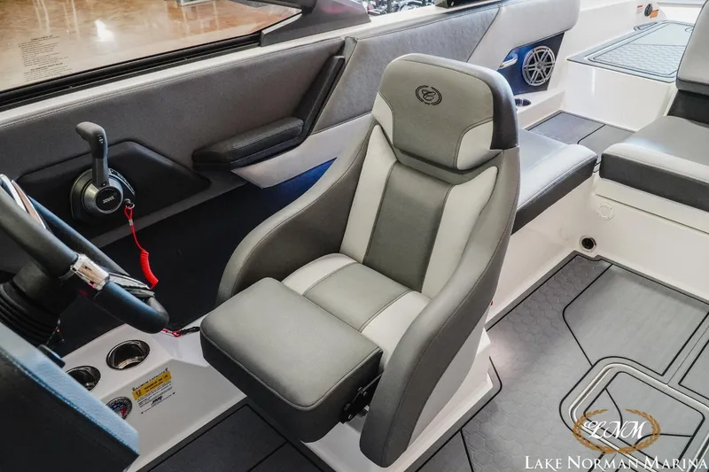 Slide: The Image of 2024 Cobalt CS23 Surf boat interior with gray captain's seat and control panel. - 16