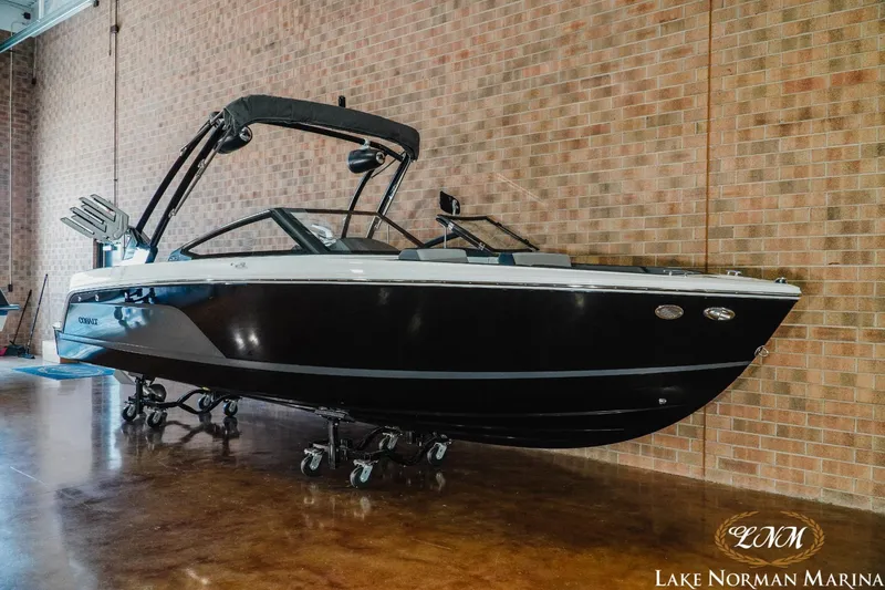 Slide: The Image of 2024 Cobalt CS23 Surf boat displayed indoors at Lake Norman Marina. - 3