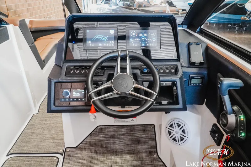 Slide: The Image of 2024 Cobalt R4 boat dashboard with modern controls and steering wheel at Lake Norman Marina. - 12