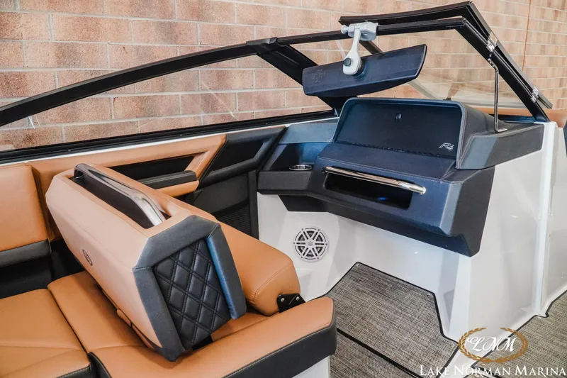 Slide: The Image of 2024 Cobalt R4 boat interior with tan and black seating, modern dashboard, and sleek design. - 13