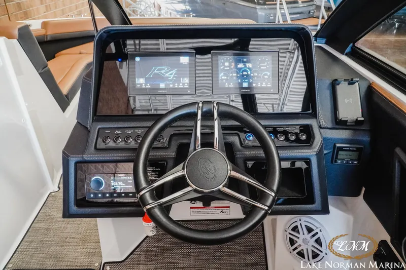 Slide: The Image of 2024 Cobalt R4 boat dashboard with steering wheel and digital displays at Lake Norman Marina. - 22