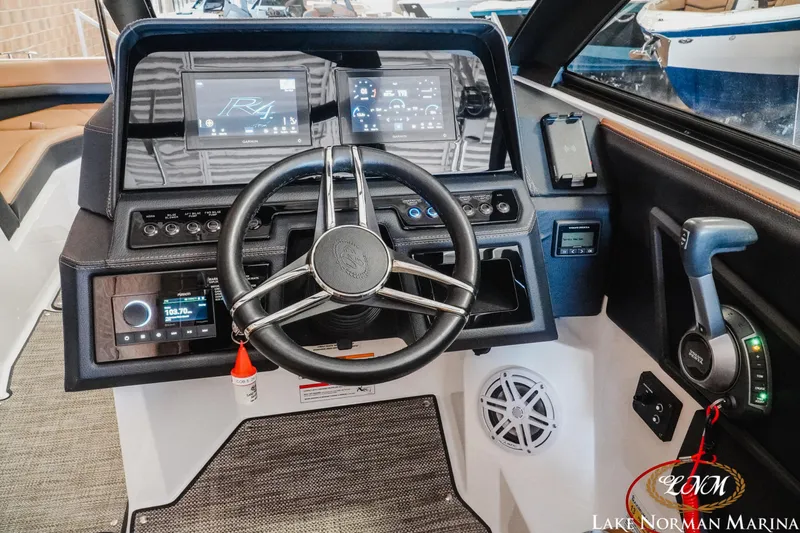 Slide: The Image of 2024 Cobalt R4 boat dashboard with steering wheel, digital displays, and control panel. - 23