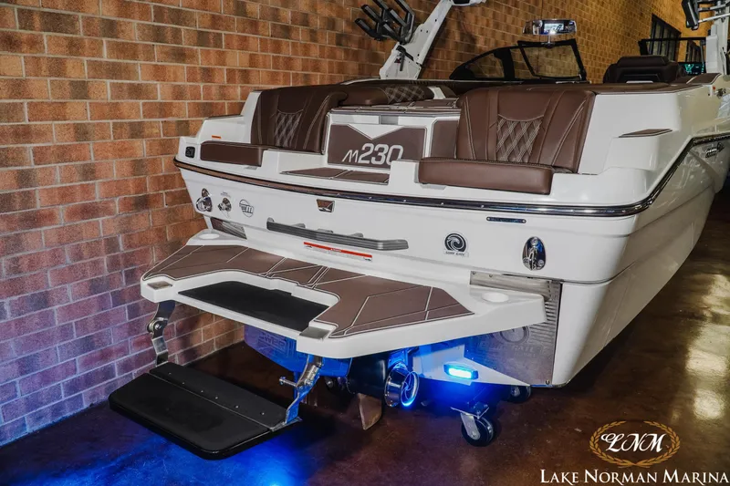 Slide: The Image of 2025 Malibu M230 boat with sleek design and modern features at Lake Norman Marina. - 10
