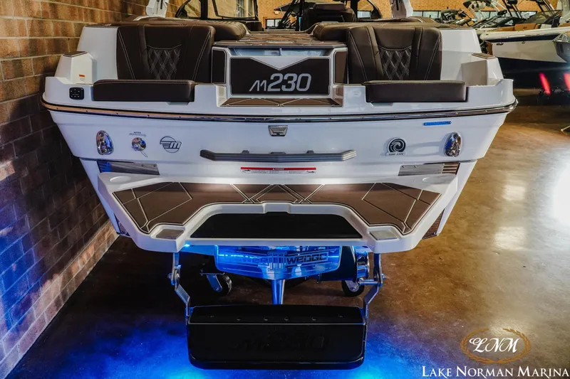 Slide: The Image of 2025 Malibu M230 boat rear view with illuminated platform at Lake Norman Marina. - 11