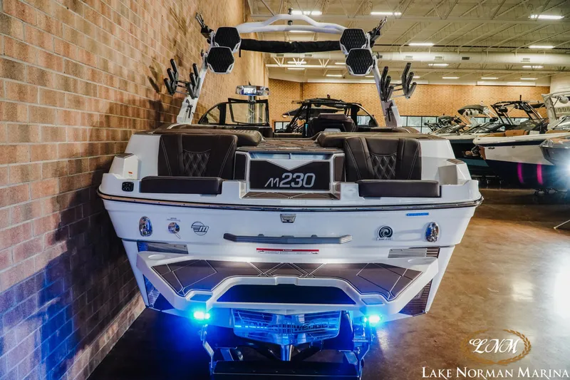 Slide: The Image of 2025 Malibu M230 boat displayed indoors at Lake Norman Marina, featuring sleek design and modern amenities. - 12