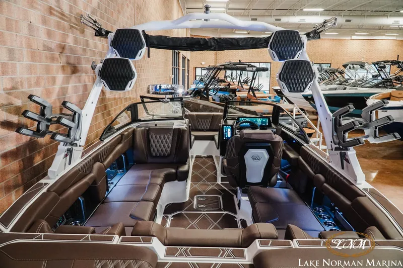 Slide: The Image of 2025 Malibu M230 boat interior with luxurious seating and advanced dashboard at Lake Norman Marina. - 13