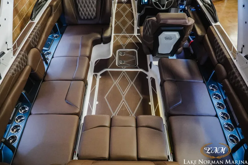 Slide: The Image of Luxurious interior of 2025 Malibu M230 boat with brown leather seating and modern design. - 15