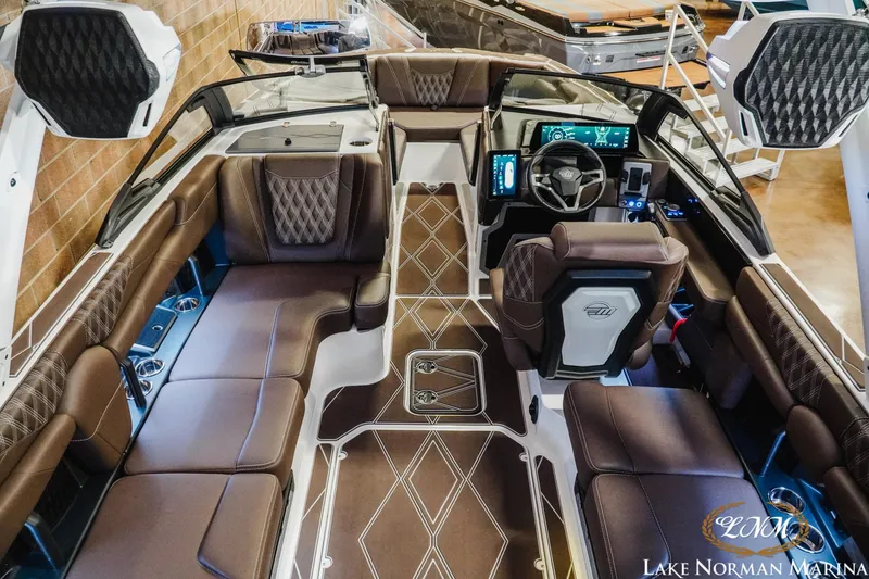 Slide: The Image of 2025 Malibu M230 boat interior with luxurious seating and modern dashboard at Lake Norman Marina. - 16