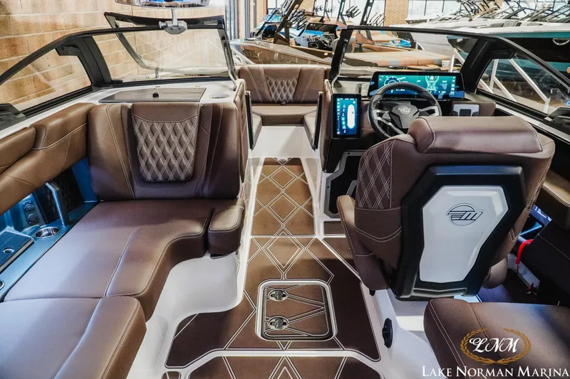 Slide: The Image of Luxurious interior of 2025 Malibu M230 boat with brown leather seating and modern dashboard. - 17